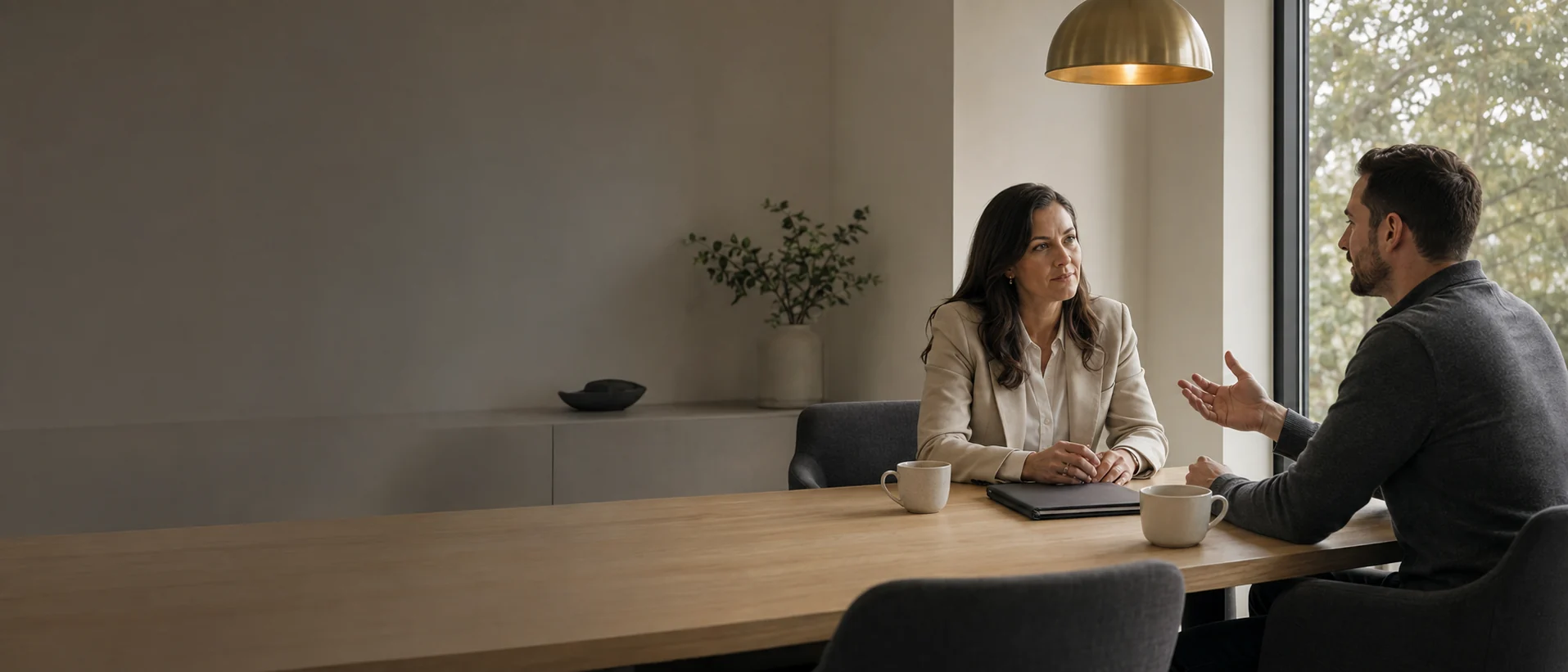 A borrower and a mortgage professional working through loan options across a conference table